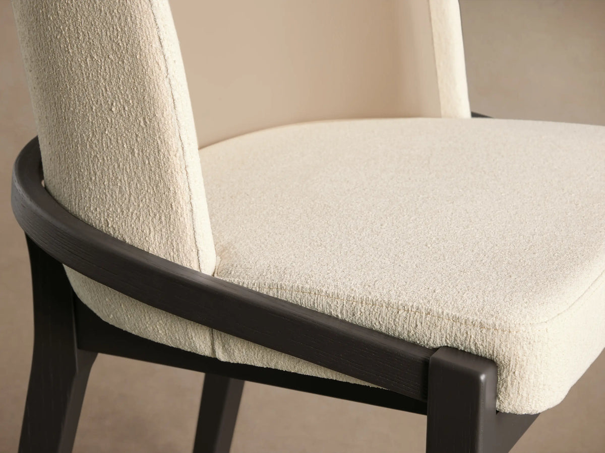 Mena Dining Chair, front view. Dark ash wood frame, tapered legs. Light cream textured seat, layered beige & cream backrest.