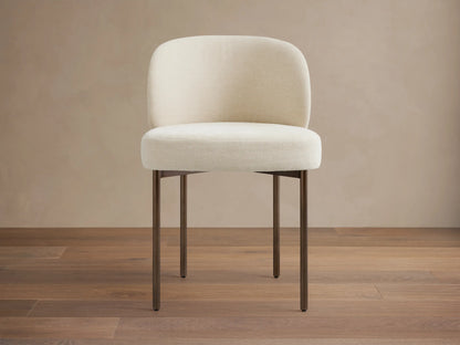 Interior view of Myers Dining Chairs, featuring greenish-gray two-tone upholstery with textured outer backs and dark metal legs.