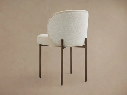 Myers Dining Chair with a curved backrest, upholstered in beige textured fabric. Features slim, dark wooden legs.