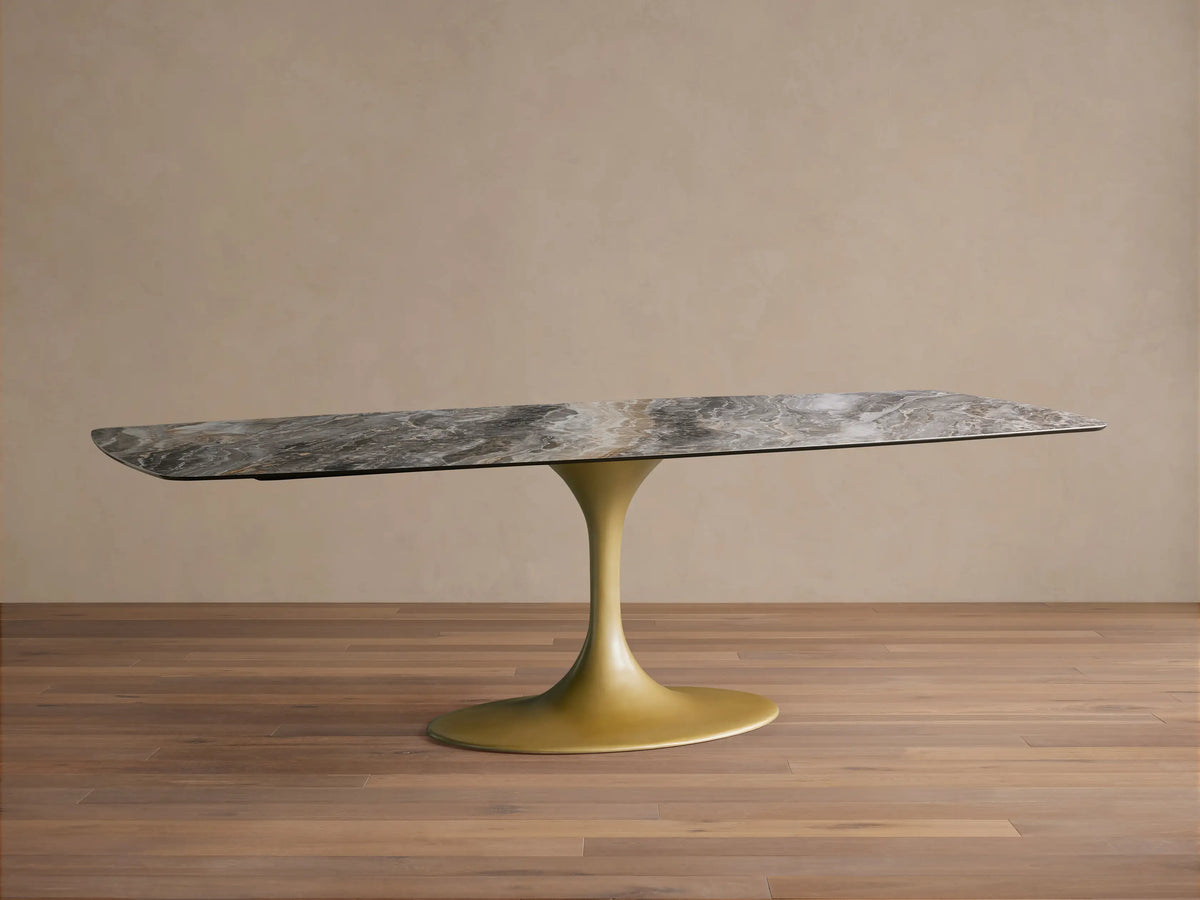 Vincenza Dining Table with Launette Base, featuring a calacatta marble-design ceramic top and gold steel base on wood floor.