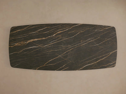 Close-up of the dark brown marble-patterned ceramic top and wavy steel base of the Ortenzia Dining Table.