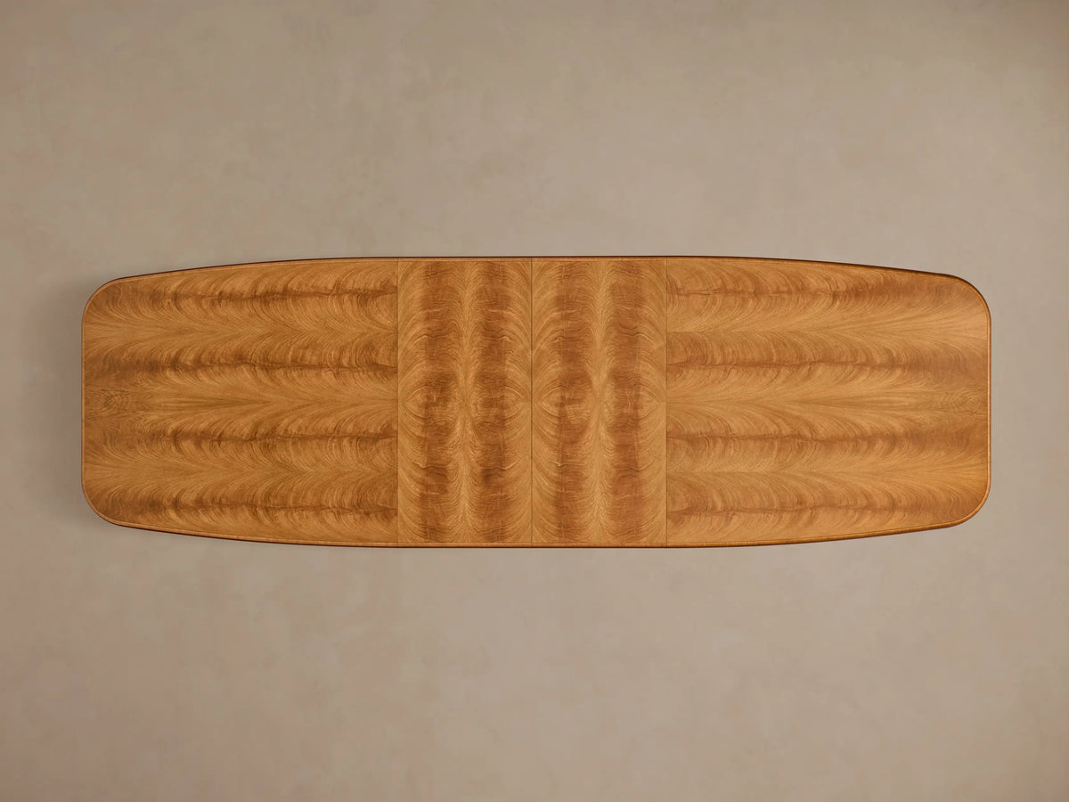 Top-down view of the extended Palma Extension Dining Table, showing rich cerajeira wood veneers with cathedral grain and two perpendicular grain leaves.