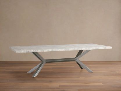 Petra Dining Table with a polished petrified wood surface and an iron base with a dark grey patina, showcased on hardwood flooring.