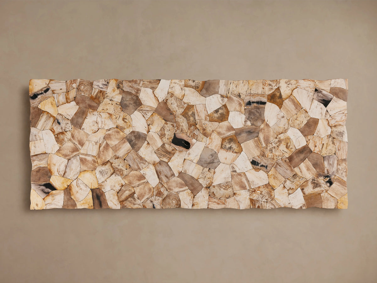 Petrified wood table with varied earthy tones and polished surface. Supported by a dark grey iron base with a cross-legged design.