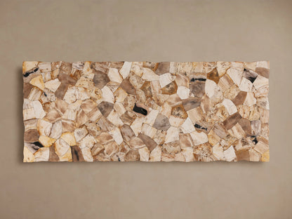 Petrified wood table with varied earthy tones and polished surface. Supported by a dark grey iron base with a cross-legged design.