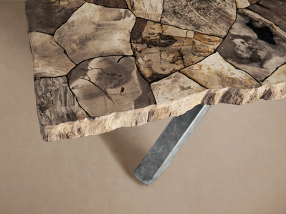 Petra Dining Table with a textured petrified wood surface and artisan-finished iron base. Features a dark grey patina.