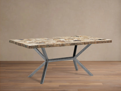 Petra Dining Table with a petrified wood top showing natural variations, supported by a V-shaped iron base with dark grey patina.