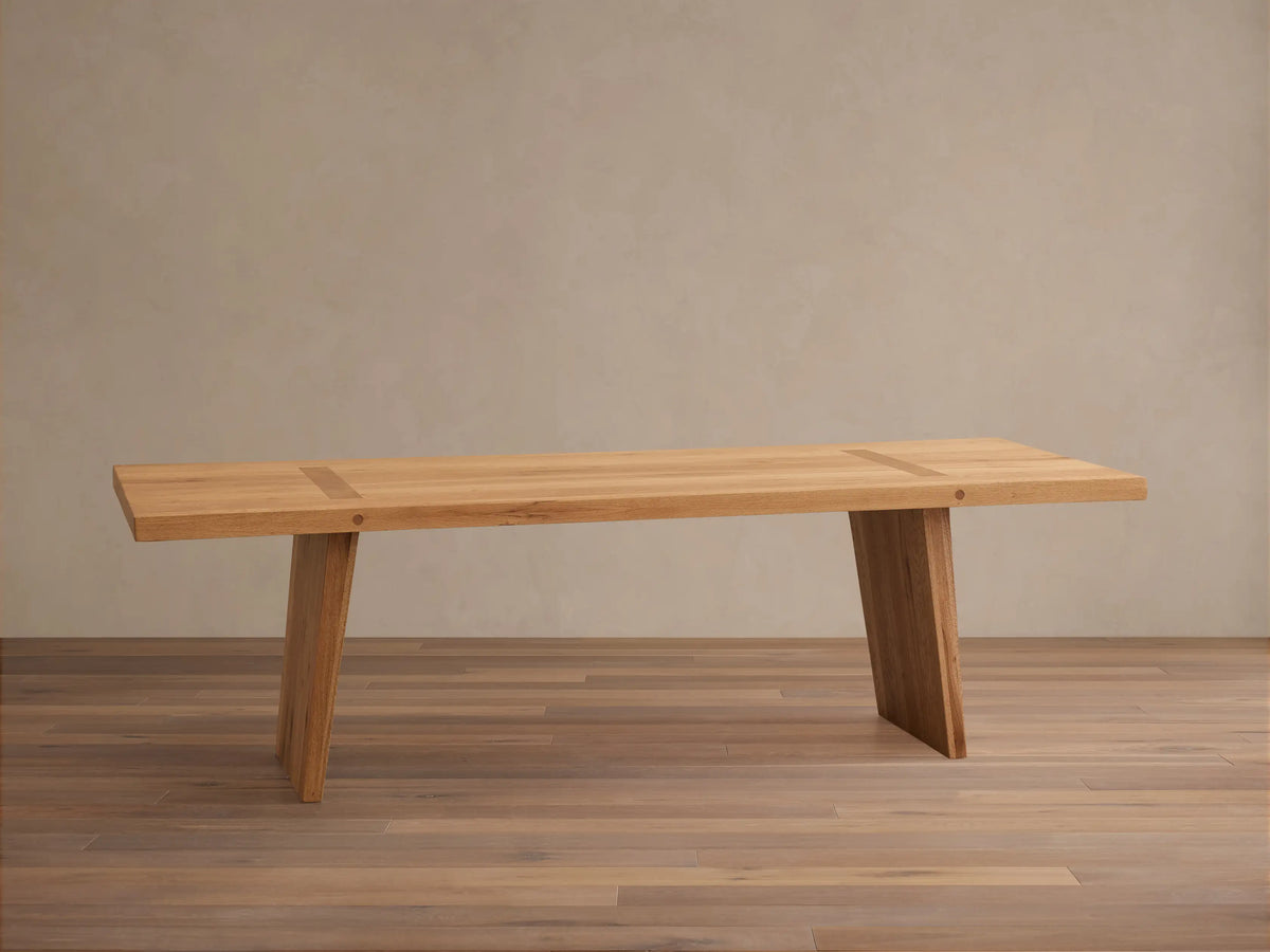 Panta Dining Table made of Romanian red oak wood, showing natural grain patterns, rectangular top, and angled legs on wooden floor.