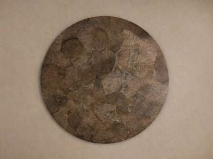 Polanco Round Dining Table: Overhead view of a textured round tabletop, made from dark brown, oyster-cut wood fragments.