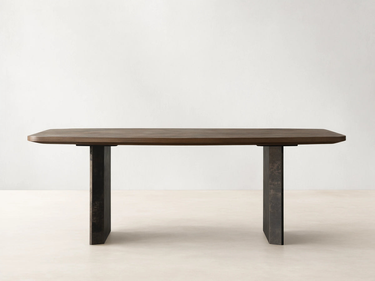 Polanco Dining Table: rectangular ash wood top with rounded corners rests on two dark, weathered steel panel bases.