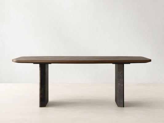 Polanco Dining Table: rectangular ash wood top with rounded corners rests on two dark, weathered steel panel bases.