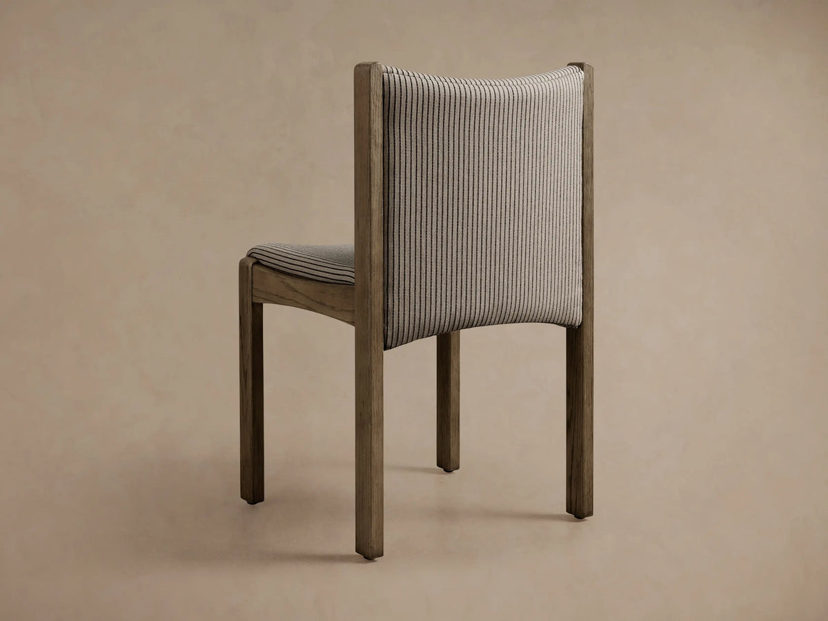 Close-up of Paradiso Dining Chair: light greyish-brown oak frame, seat and back upholstered in light grey fabric with thin dark stripes.