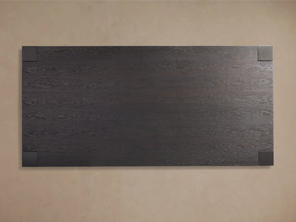 A close-up of the Parsons Dining Table's corner showing its dark oak wood texture and subtle sheen from the lacquer finish.