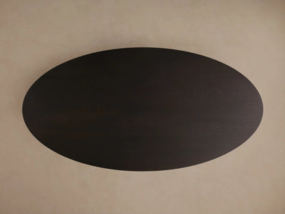 Close-up of the dark brown Perth Oval Dining Table showing the smooth, rounded edge of the top and sculptural, rounded base.