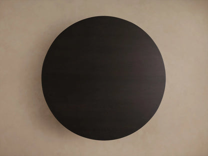 Close-up, high-angle view of a dark wood round table, highlighting its distinctive light gray wood grain texture and curved edge.