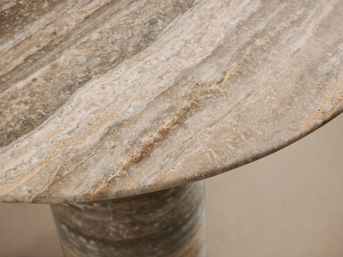 Perth Stone Bistro Table with a round top and a tapered cylindrical base, displaying natural stone patterns in earthy brown, beige, and grey.