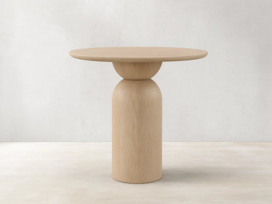 Front view of the light natural wood Perth Bistro Table with a round top and a sculptural pedestal base.