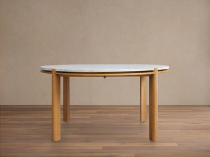 Pyet Round Dining Table with white Carrara marble top and four solid red oak wood legs on a wooden floor.