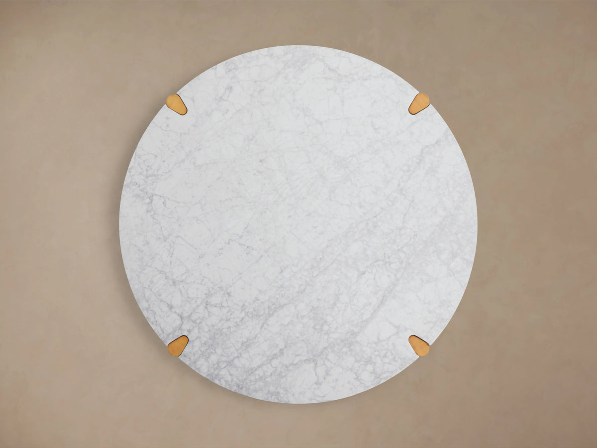 Round Pyet Dining Table with a white Carrara marble top and solid red oak wood base, showing natural grain and finish.