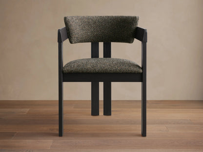 Side profile of the black ash wood Rodin Dining Arm Chair with speckled green-grey upholstered seat and back cushion.