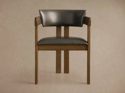 Rodin Faux Leather Arm Chair. Dark brown wooden frame with dark gray faux leather seat and back, angled on wood floor.