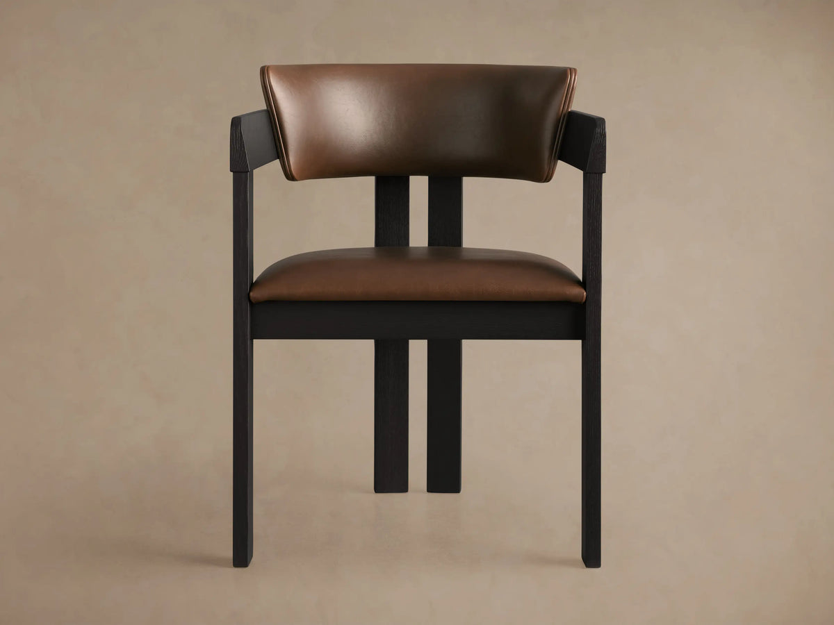 Rodin Faux Leather Arm Chair: angled view of dark ash wood frame with brown faux leather seat and curved back, on wood floor.