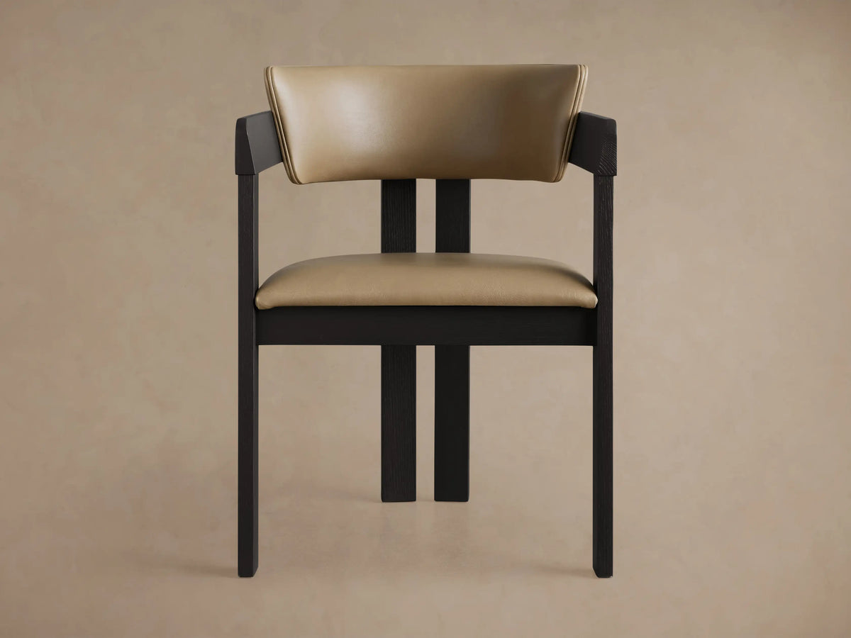 Rodin Faux Leather Arm Chair with black ash wood frame, light beige faux leather seat/back, angled on wooden floor.