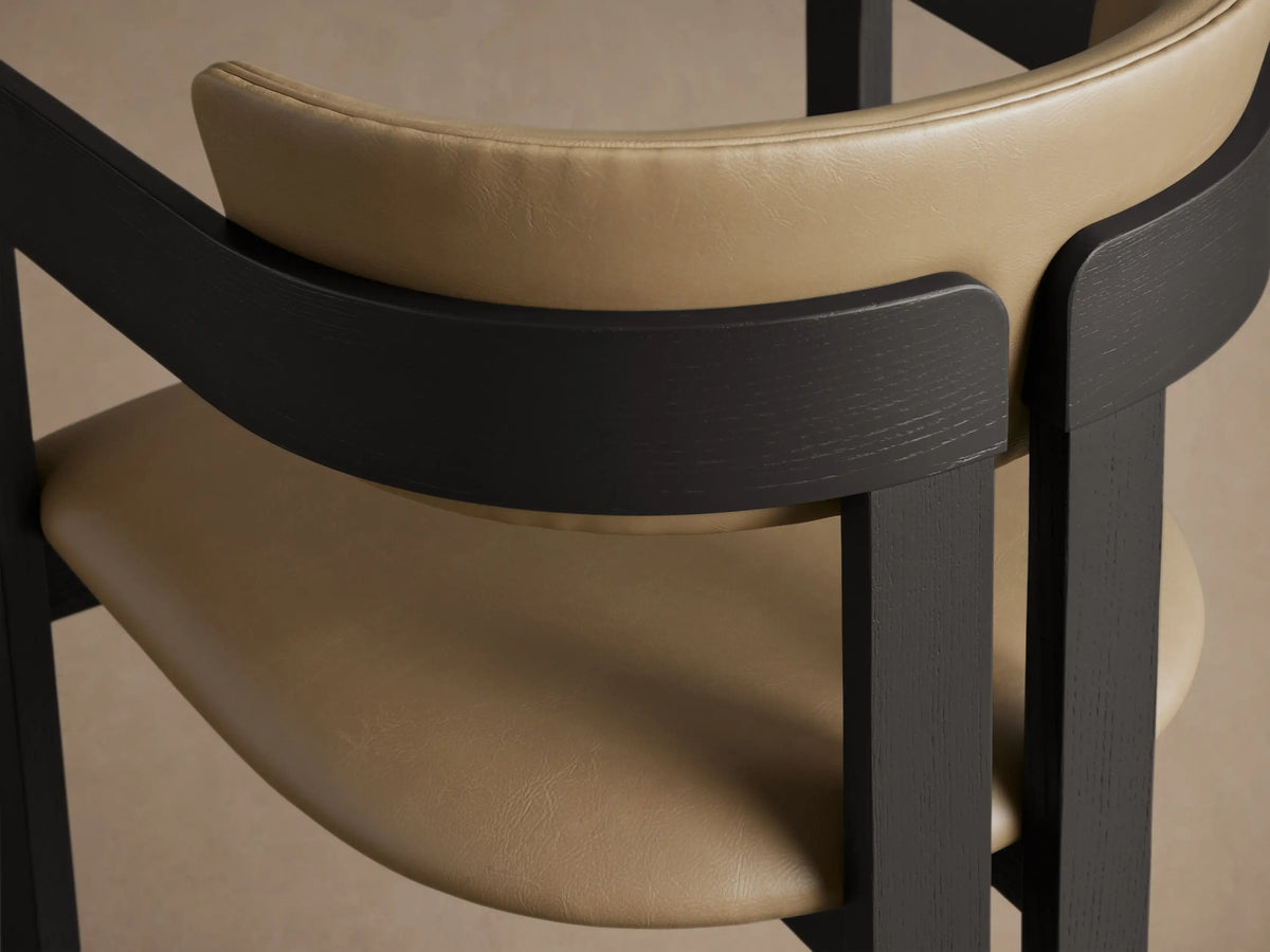 Front view of a Rodin Faux Leather Arm Chair with a dark ash wood frame and tan faux leather seat and back.