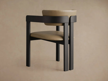 Close-up of Rodin Faux Leather Arm Chair. Dark ash wood frame with a curved back and light tan faux leather upholstery.
