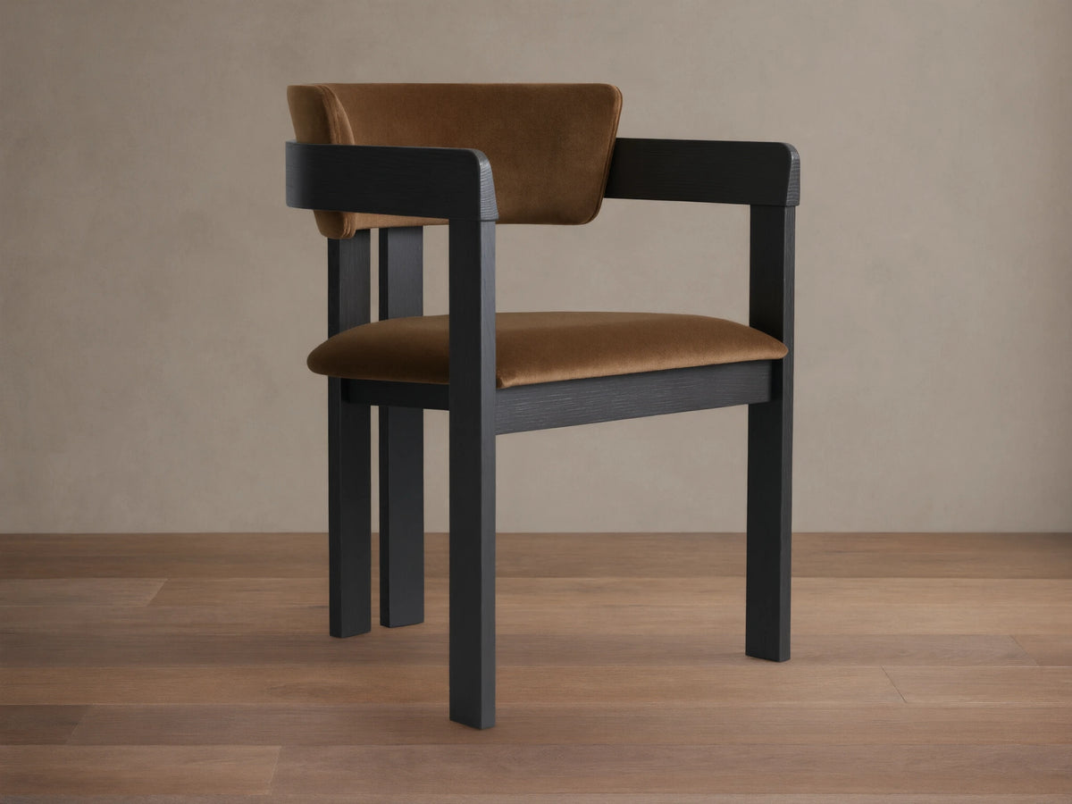 Rodin Dining Arm Chair made of ash wood with a dark frame and light brown cushioned seat and backrest, on a wooden floor.
