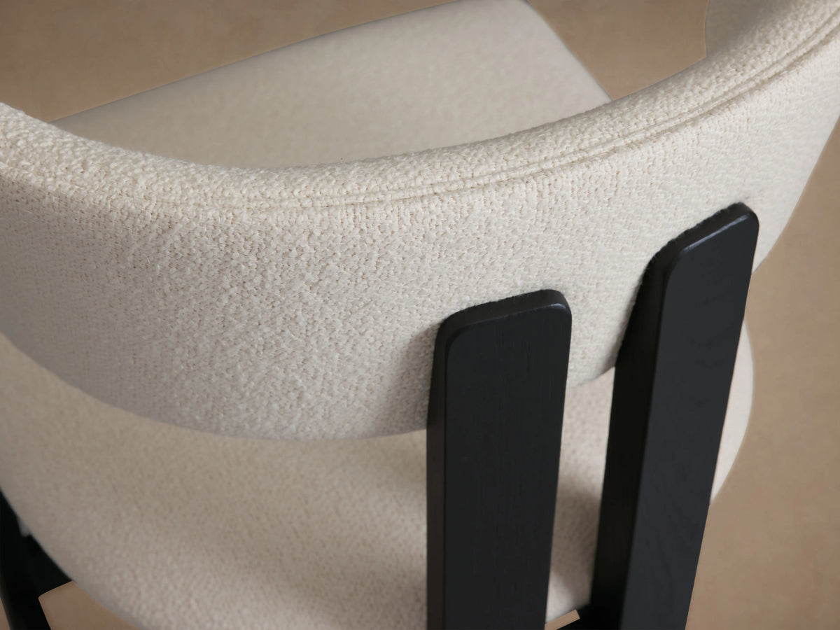 Rodin Armless Stool with a cream upholstered seat and backrest on a dark ash wood frame. Back view showing sleek, curved lines.