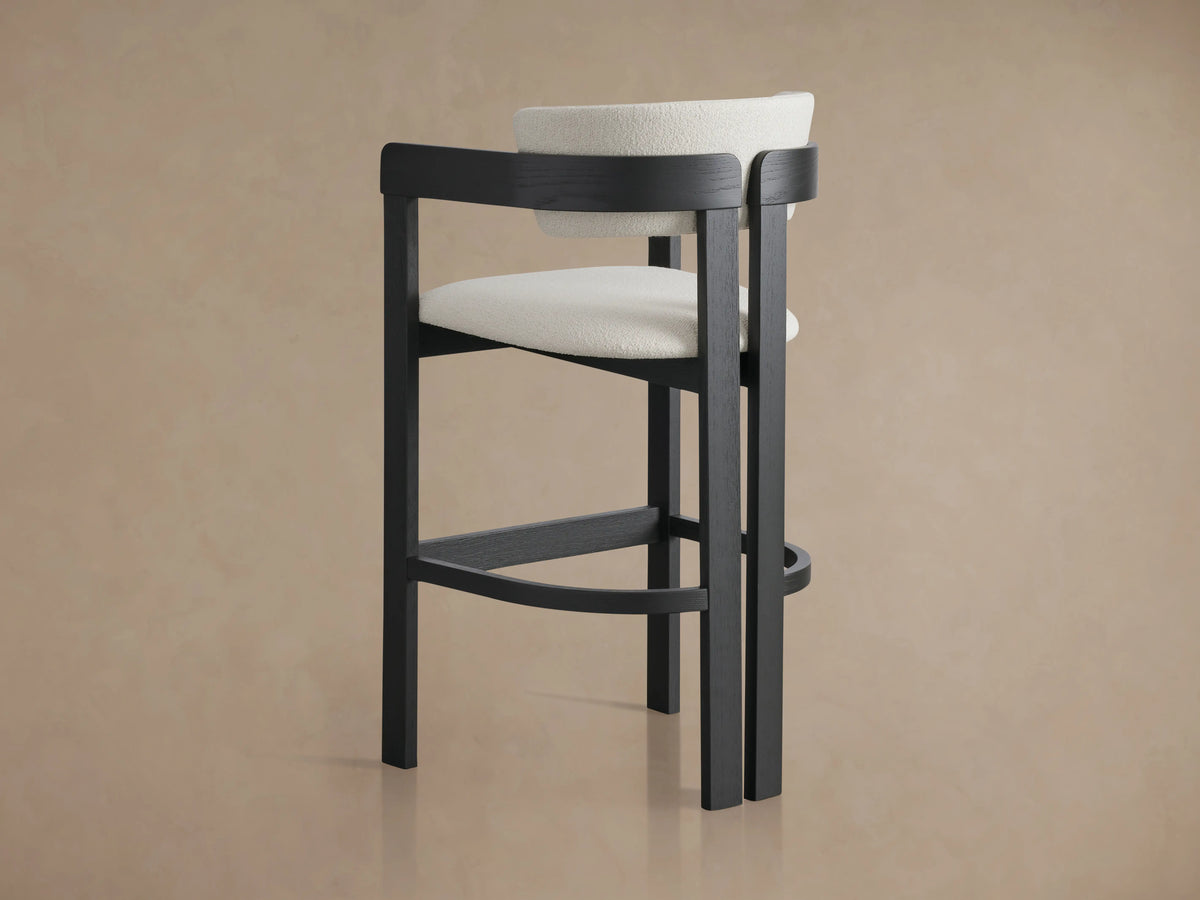 Rodin Stool with curved, upholstered backrest in white Matera Performance Fabric. Dark ash wood frame, viewed from above.