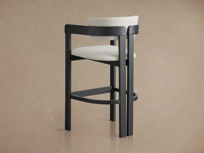 Rodin Stool with curved, upholstered backrest in white Matera Performance Fabric. Dark ash wood frame, viewed from above.