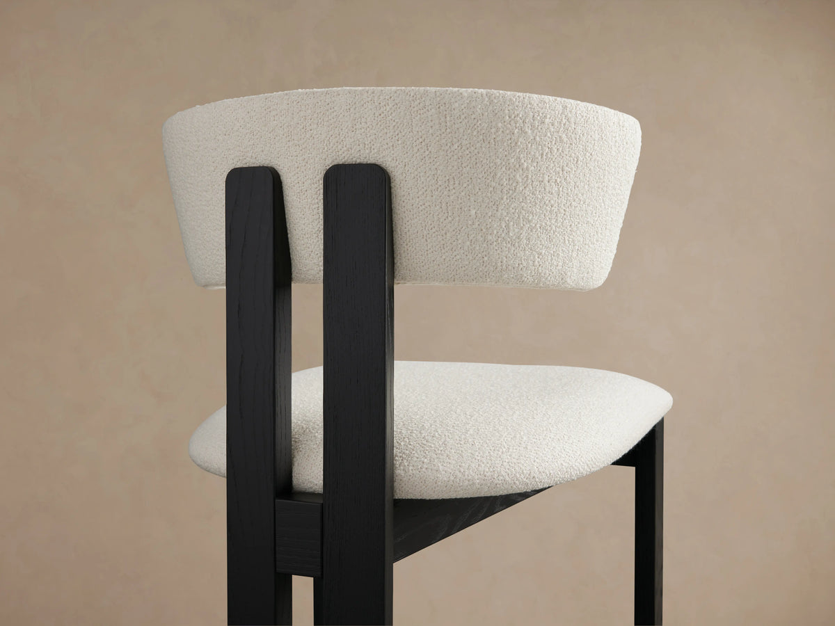 Rodin Dining Side Chair made of ash wood, featuring a curved backrest and cushioned seat in cream fabric, with a black frame.