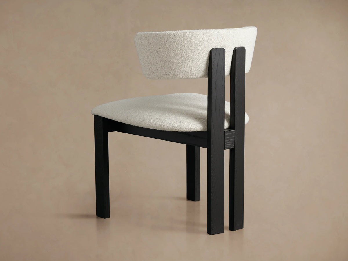 Rodin Dining Side Chair featuring a light beige fabric backrest and seat, with a dark ash wood frame. Hintergrund in neutralem Beige zeigt modernes Design.