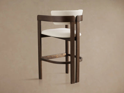 The Rodin Stool features a dark ash wood frame with a rectangular back and seat upholstered in soft, light beige fabric.
