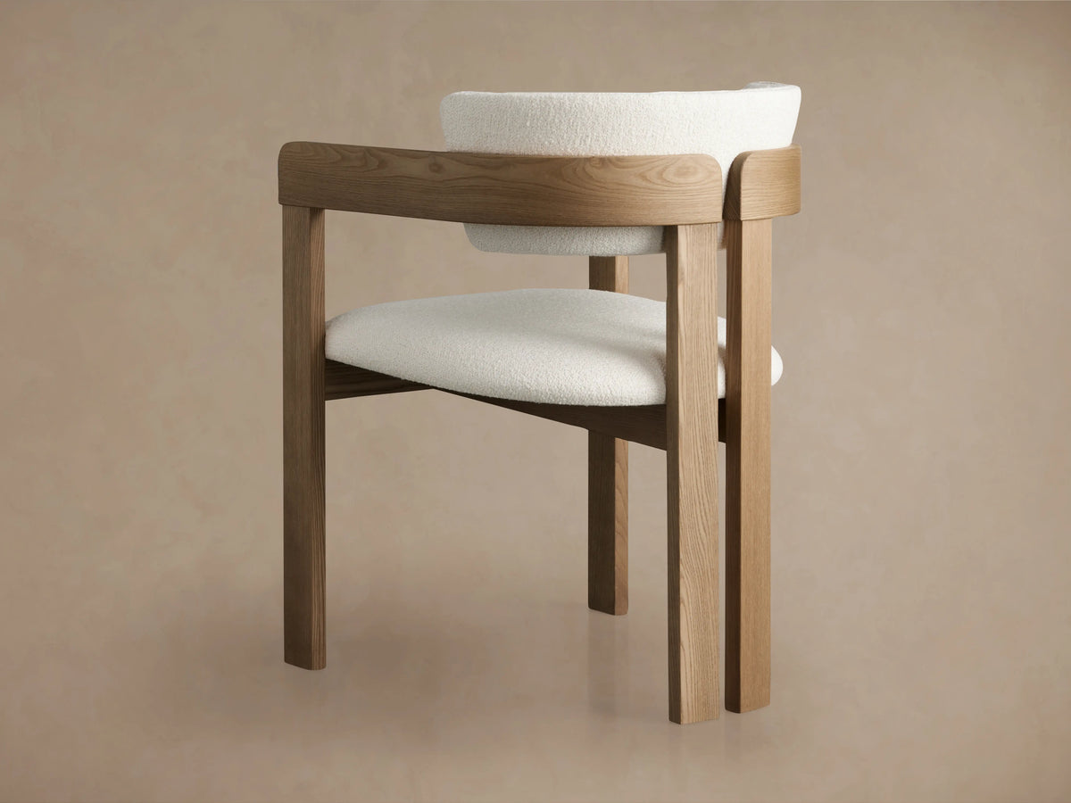 Rodin Dining Arm Chair in Natural, featuring a curved ash wood backrest with soft, textured white fabric upholstery and elegant grain.