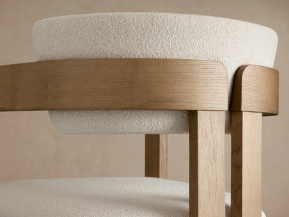 Rodin Barstool in Natural ash wood with a white upholstered seat and backrest, viewed from the front. The barstool rests on a wooden floor.