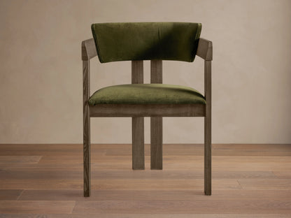 Rodin Dining Arm Chair in Vance Olive features an ash wood frame with olive green fabric, armrests, and a cushioned seat.