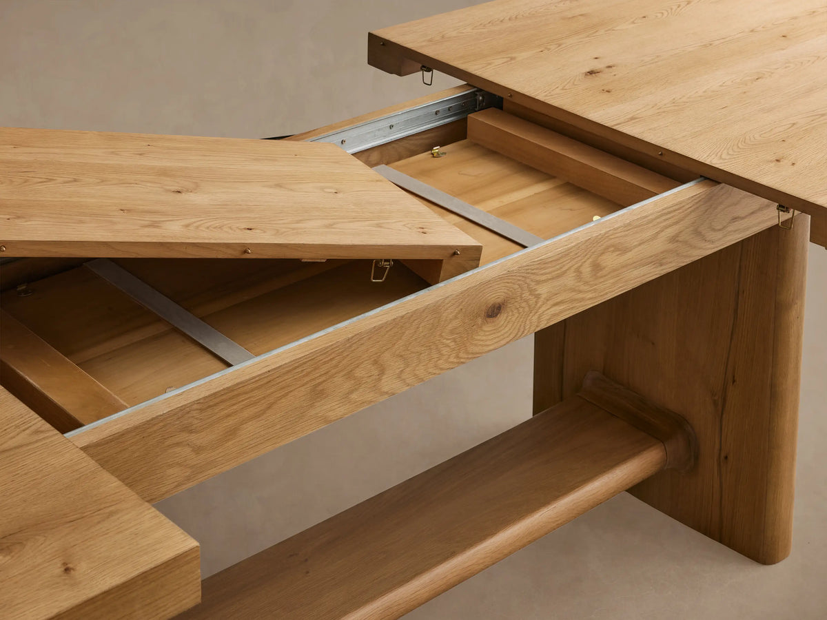 Close-up of Redding Extension Dining Table's natural light oak wood tabletop with rounded corner, visible grain, and leg.