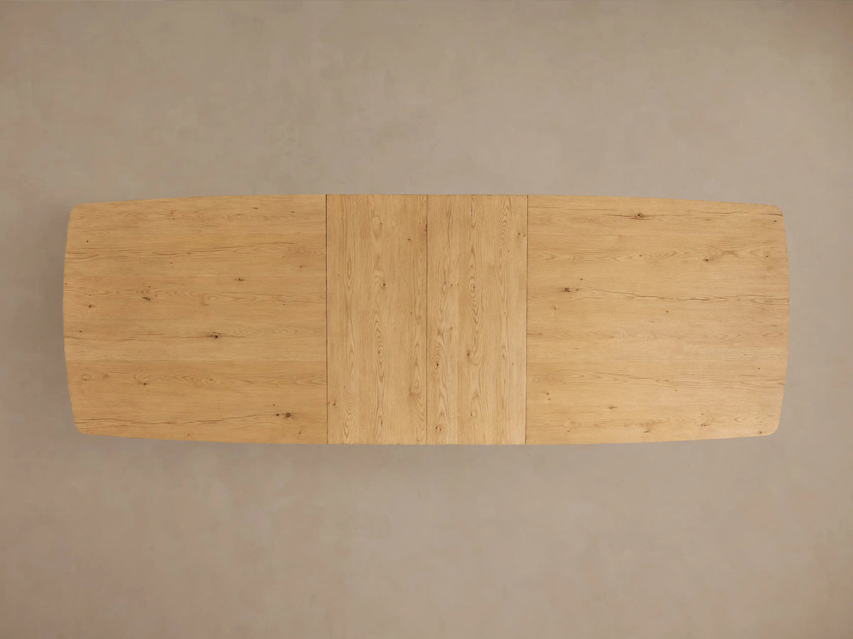 Redding Extension Dining Table of light oak wood. Rectangular top with rounded corners, visible extension seam, sturdy block legs.