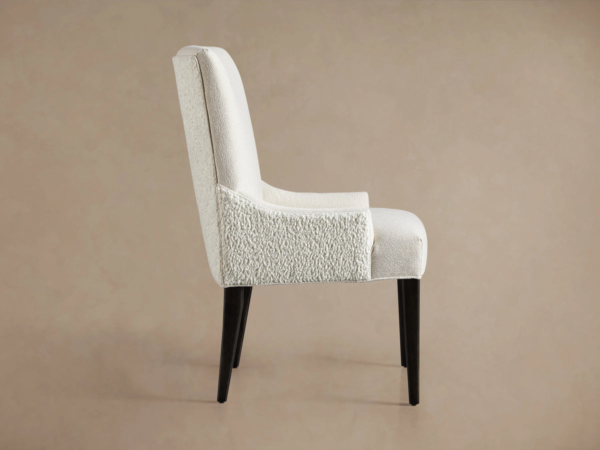 Rhen Dining Chair with white textured fabric backrest, tall and slightly curved, resting on four dark wooden legs.