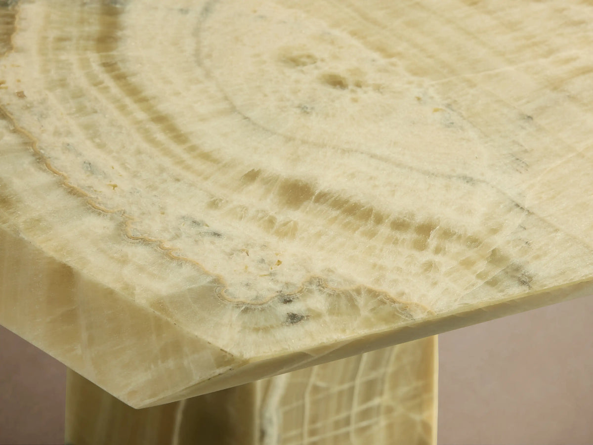 Zyra Stone Dining Table: light green onyx with natural veining, a long rectangular top, and two thick, tapered legs.