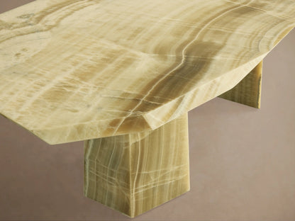Close-up of Zyra Stone Dining Table's light creamy onyx surface, with natural, wavy patterns and layered texture.