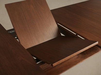 Ross Extension Dining Table, crafted from solid walnut, features patina brass leg caps and a mid-century design with a floating shelf detail.