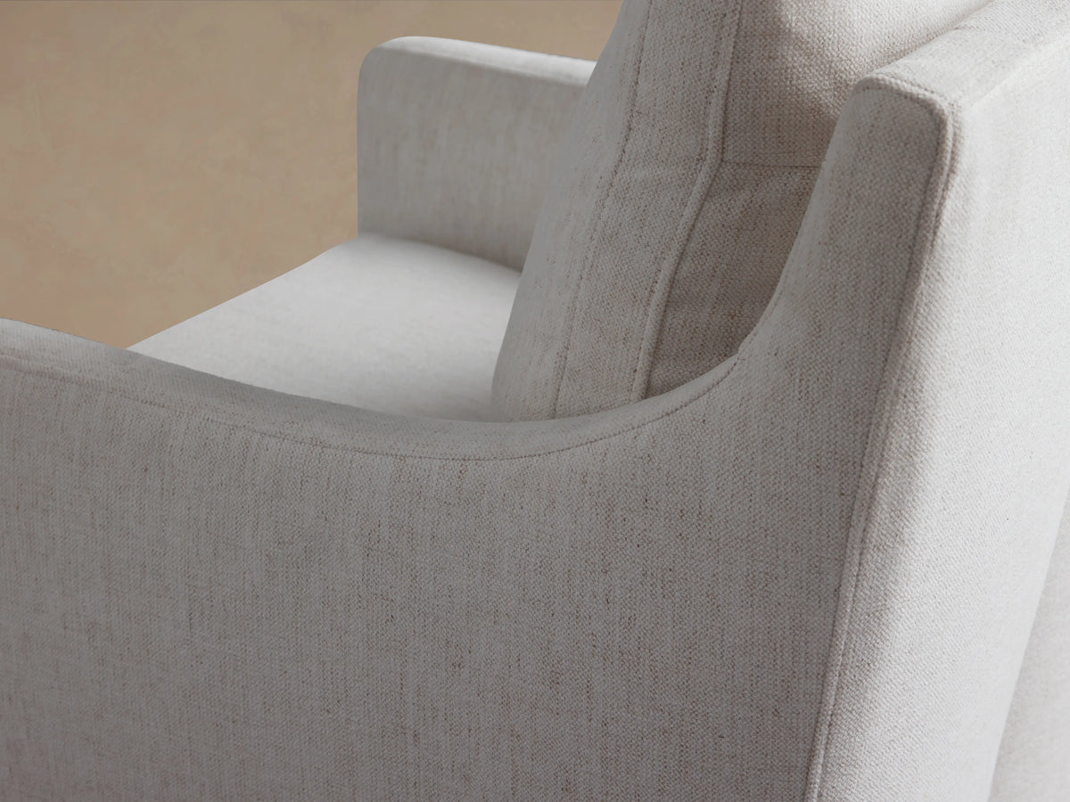 Samantha Dining Chair in light beige fabric, featuring padded backrest and seat cushions on hardwood frame, placed on wooden floor.
