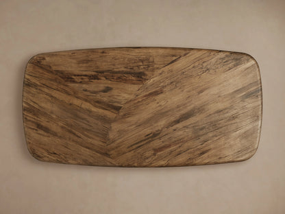 San Rafael Dining Table in primavera wood with a semi-matte finish, featuring a curved base and oval top, on hardwood floor.