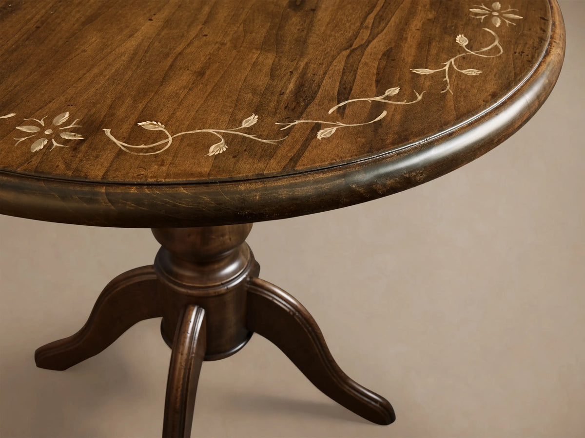 Front view of the brown Stefania Bistro Table with a round top, hand-painted botanical border, and a turned pedestal base.