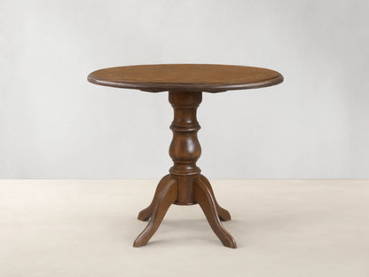 Front view of the brown Stefania Bistro Table with a round top, hand-painted botanical border, and a turned pedestal base.