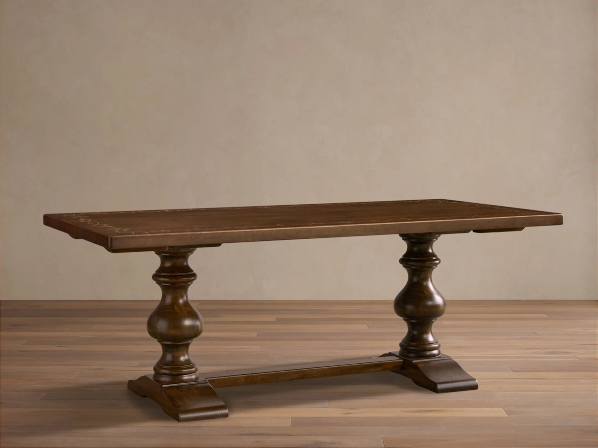 Front view of the brown Stefania Oval Extension Dining Table with a hand-painted botanical motif and hand-turned pedestal legs.